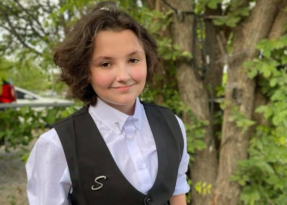 Nex Benedict poses outside the family's home in Owasso, Okla., last December. The nonbinary teenager died in February after a school bathroom fight. The state medical examiner's office said the teen's death has been ruled a suicide.