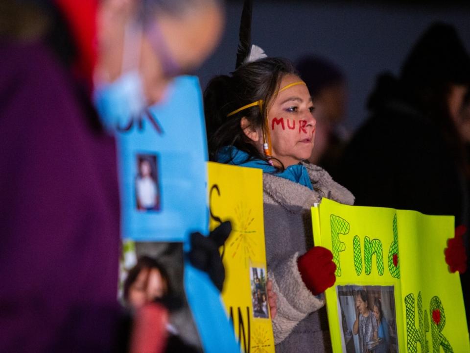 Pamela Myran holds a poster that says 'Find her' at a vigil honouring MMIWG at Oodena Celebration Circle in Winnipeg on Sunday. Her daughter, Marcedes Myran, is one of the women Jeremy Skibicki is charged with killing. (Chelsea Kemp/CBC - image credit)