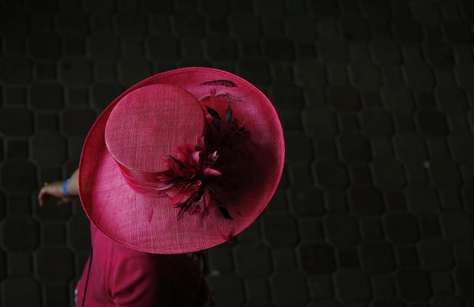 A woman makes her way to the track before the 140th running of the Kentucky Derby horse race at Churchill Downs Saturday, May 3, 2014, in Louisville, Ky. (AP Photo/Matt Slocum)