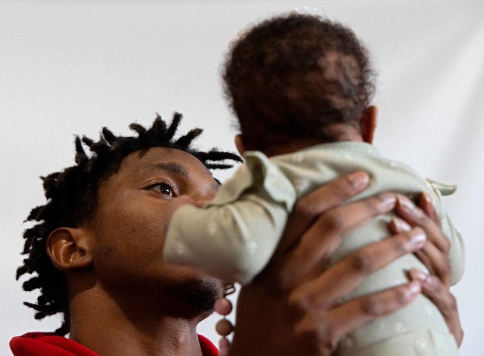 N.C. State’s Rakeim Ashford holds his three-month-old daughter, Ra’Kiya, on Tuesday, Nov. 14, 2023, at the Wendell Murphy Football Center in Raleigh, N.C.