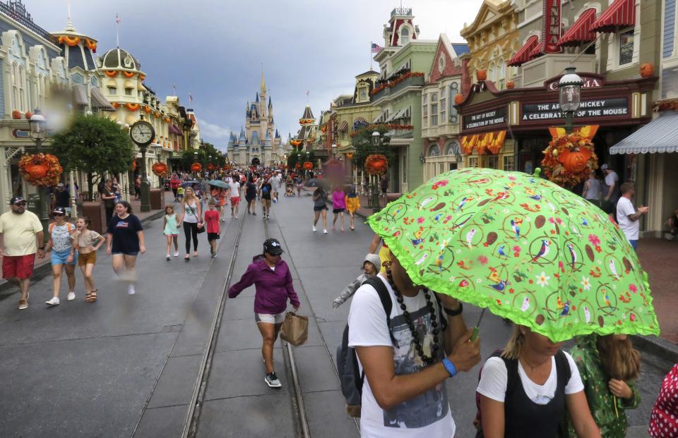 Guests leave the Magic Kingdom at Walt Disney World Tuesday, Sept. 3, 2019, in Lake Buena Vista, Fla., after the park closed early due to weather spawned by Hurricane Dorian. (Joe Burbank/Orlando Sentinel via AP)