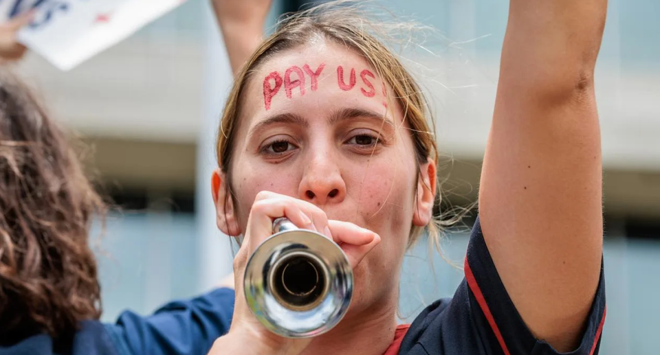 A NSW nurse with the words 'pay us!' painted on her forehead, as healthcare workers in the state demand pay increases. 