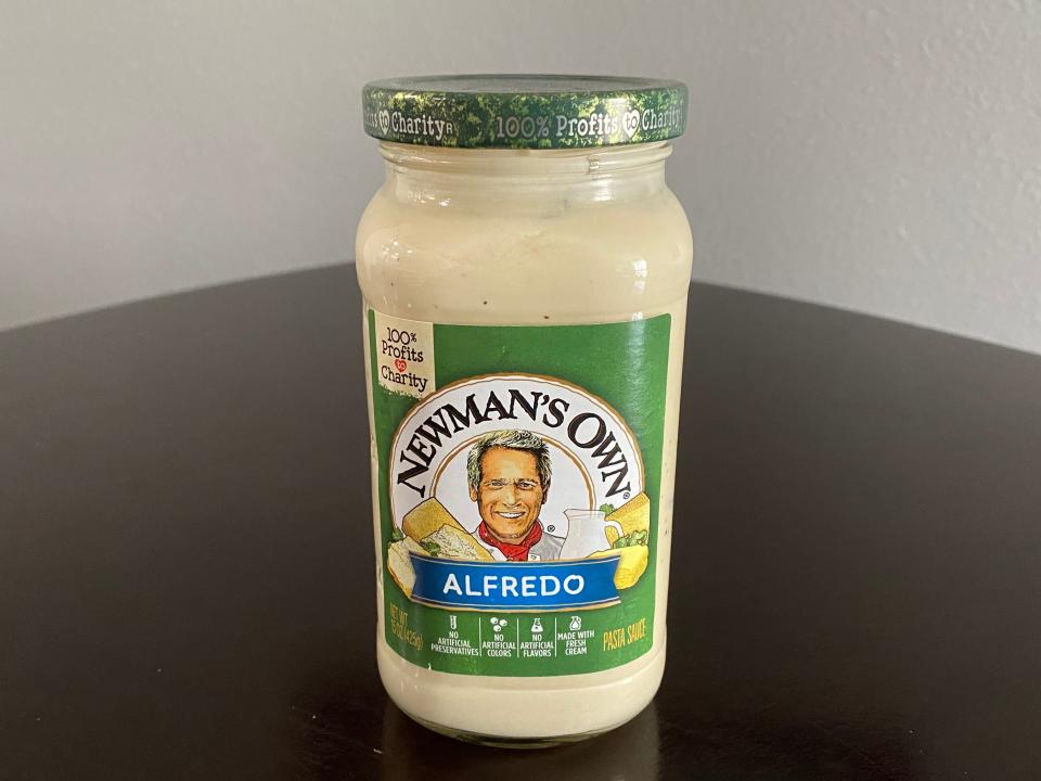 Jar of Newman's Own Alfredo sauce on a black table