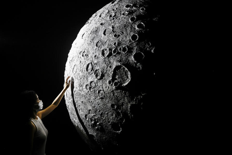 WUHAN, CHINA - OCTOBER 2: (CHINA OUT)The visitor touch to model of moon during Explore CASCI(China Aerospace Science and Cultural Innovation) ART Exhibition on October 2, 2022 in Wuhan, Hubei province, China. China is celebrating its 73nd National Day and a week-long holiday known as the 