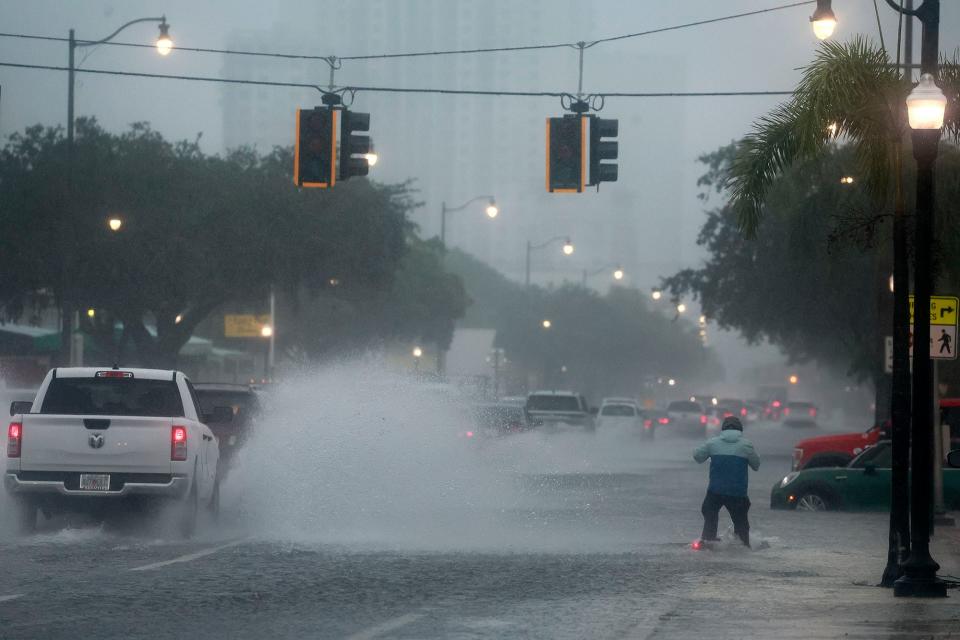 A man on a scooter tries to go through flooded streets on Federal Highway in Hollywood, Fla., Wednesday, June 12, 2024. (Mike Stocker/South Florida Sun-Sentinel via AP)