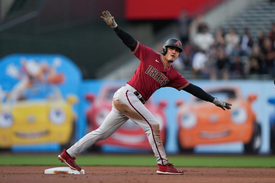 Arizona Diamondbacks third baseman Josh Rojas (10) signals after sliding in safe during the first inning against the San Francisco Giants at Oracle Park.