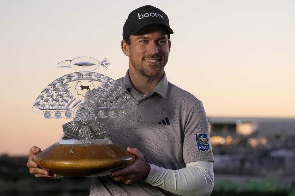 Nick Taylor, of Canada, poses with the trophy after winning the Phoenix Open golf tournament Sunday, Feb. 11, 2024, in Scottsdale, Ariz. (AP Photo/Ross D. Franklin)