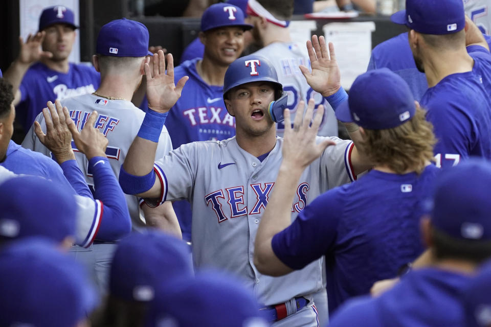 Texas Rangers' Josh Jung celebrates in the dugout after scoring on a double by Adolis Garcia during the first inning of a baseball game against the Chicago White Sox Monday, June 19, 2023, in Chicago. (AP Photo/Charles Rex Arbogast)