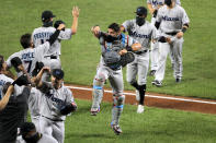 Miami Marlins catcher Francisco Cervelli, center, reacts he engages with teammates in a social distant celebration after defeating the Baltimore Orioles 4-0 during a baseball game, Tuesday, Aug. 4, 2020, in Baltimore. (AP Photo/Julio Cortez)