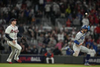 Atlanta Braves third baseman Austin Riley, left, throws the ball to Braves shortstop Dansby Swanson who tagged out Los Angeles Dodgers' Chris Taylor (3) after being caught in a run down on base hit by Dodgers' Cody Bellinger during the ninth inning in Game 1 of baseball's National League Championship Series Saturday, Oct. 16, 2021, in Atlanta. (AP Photo/Ashley Landis)