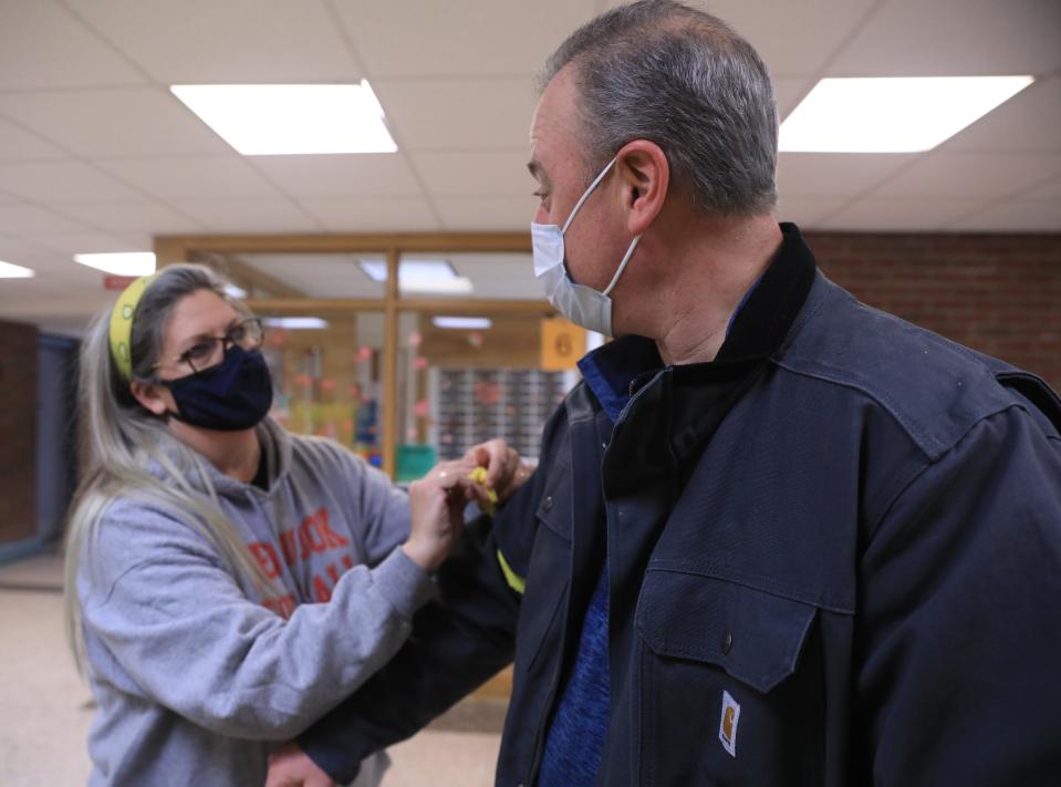 Alexandra Brenner ties a yellow ribbon on Alan Angelone's sleeve for Highland's Zach Osterhoudt before Friday's boys basketball game at Red Hook on February 18, 2022. 