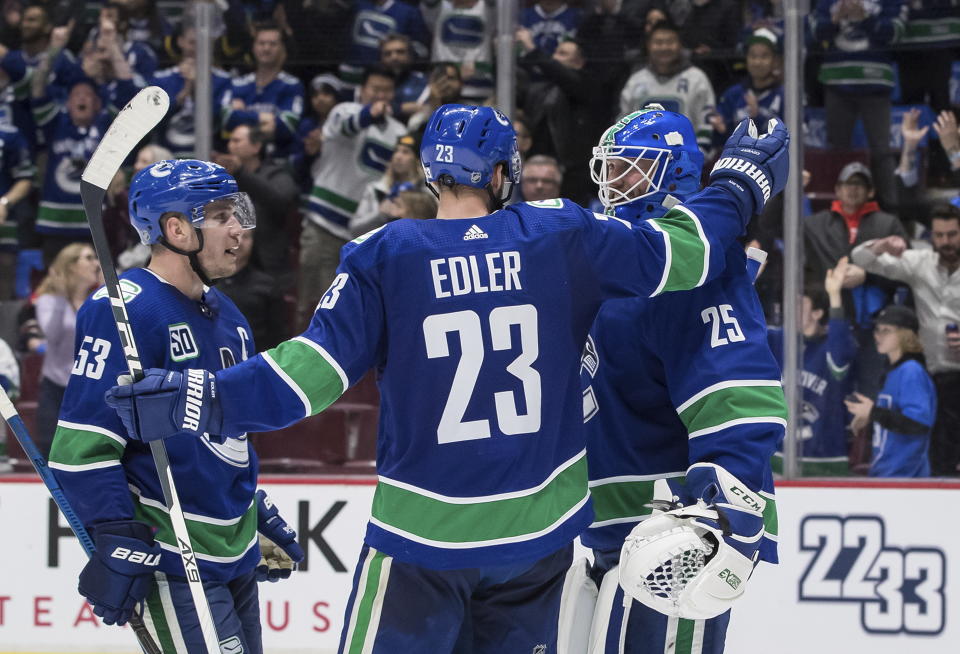 Vancouver Canucks' Bo Horvat, Alexander Edler and goalie Jacob Markstrom celebrate after Vancouver defeated the Chicago Blackhawks 3-0 during an NHL hockey game Wednesday, Feb. 12, 2020, in Vancouver, British Columbia. (Darryl Dyck/The Canadian Press via AP)