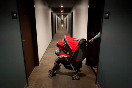 Puerto Rican Debora Oquendo, 43, pushes her baby pram into a hall of a hotel where she lives with her 10-month-old daughter, in Orlando, Florida, U.S., December 12, 2017. REUTERS/Alvin Baez