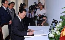 Vietnam's Prime Minister Nguyen Tan Dung writes down a message of condolence for Lee Kuan Yew at the Singaporean embassy in Hanoi, on March 23, 2015