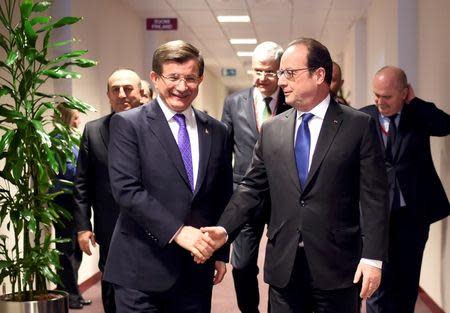 France's President Francois Hollande (R) shakes hands with Turkish Prime Minister Ahmet Davutoglu (L) before a meeting during a European Union leaders summit on migration in Brussels, Belgium, March 18, 2016. REUTERS/Stephane de Sakutin/Pool