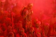 <p>Indian revellers covered in coloured powder sit inside a temple during prayers held as part of the Lathmar Holi celebrations in the village of Nandgaon on March 18, 2016. </p>