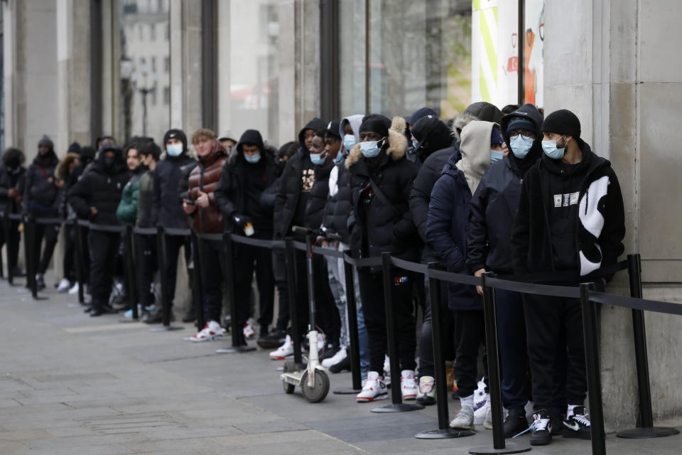 A queue grows big as people wait to enter a Nike Town shop on Oxford Street in London, early Monday morning, April 12, 2021. Millions of people in England will get their first chance in months for haircuts, casual shopping and restaurant meals on Monday, as the government takes the next step on its lockdown-lifting road map. (AP Photo/Kirsty Wigglesworth)