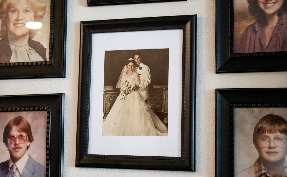 A photo of John and Jeannine Binder on their wedding day hangs alongside portraits of their six children in Jeannine’s Shawnee home. Jeannine continues to benefit from the services of a death doula even after John’s death in April. Nick Wagner/nwagner@kcstar.com