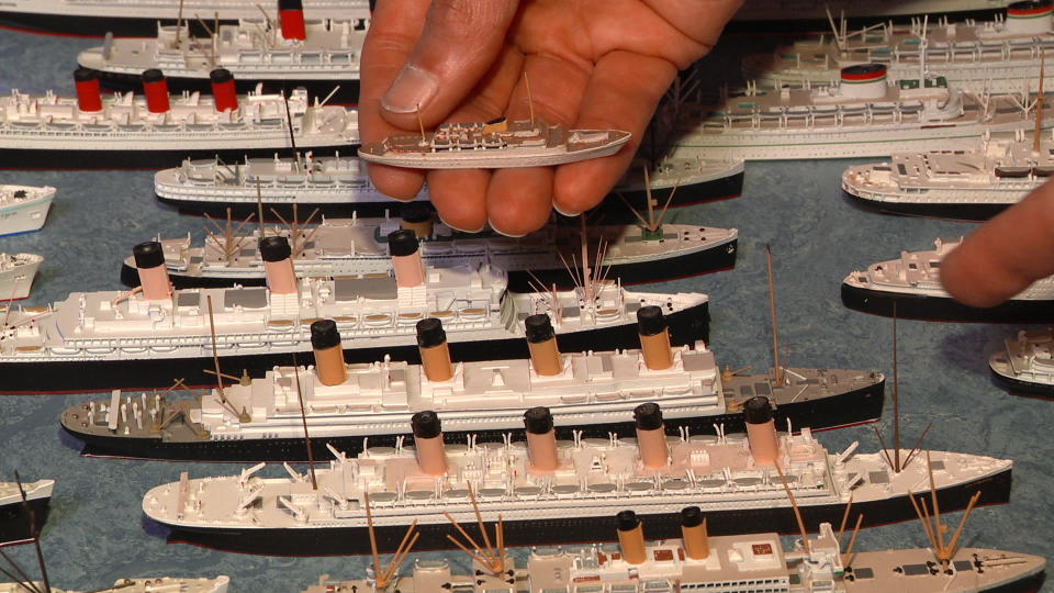 Peter Knego shows a scale model of the Aurora (nee Wappen Von Hamburg) compared to a scale model of the Titanic. / Credit: CBS News