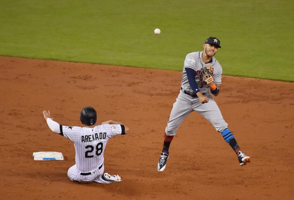 <p>American League infielder Carlos Correa (1) of the Houston Astros turns a double play over National League infielder Nolan Arenado (28) of the Colorado Rockies in the second inning during the 2017 MLB All-Star Game at Marlins Park. </p>