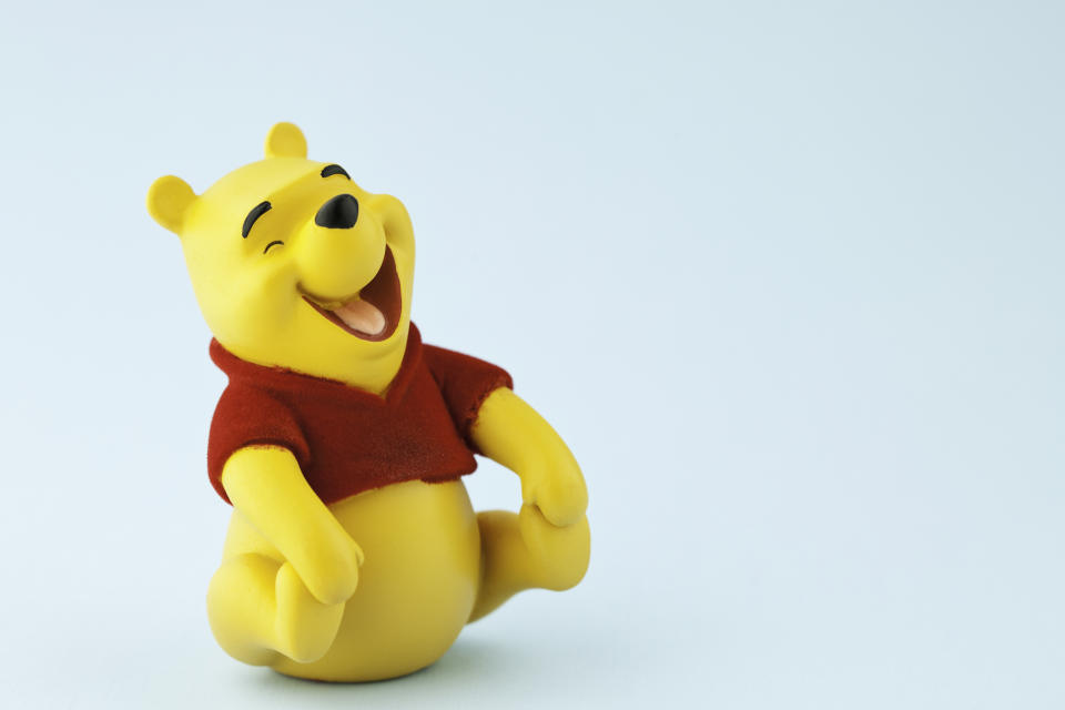 Suffolk, Virginia, USA - April 21, 2011: A horizontal studio shot of the Disney character Winnie the Pooh shot on a blue background. Winnie the Pooh was originally created by English author A.A. Milne.