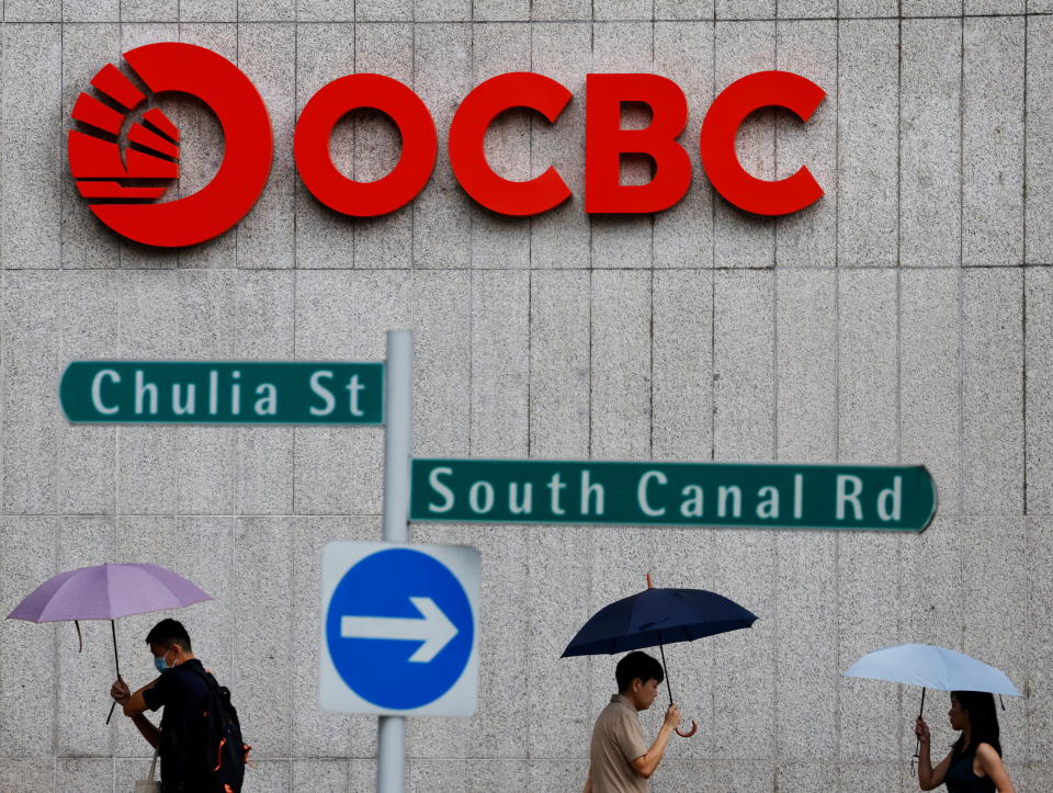 People pass an OCBC Bank signage in Singapore.