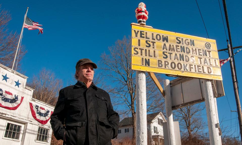 John D. Holdcraft stands by his sign on Route 9 in Brookfield March 4, 2021.