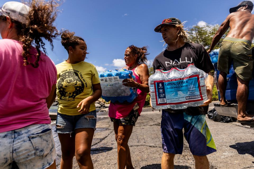 Volunteers load supplies onto a boat for West Maui on 13 August (AP)