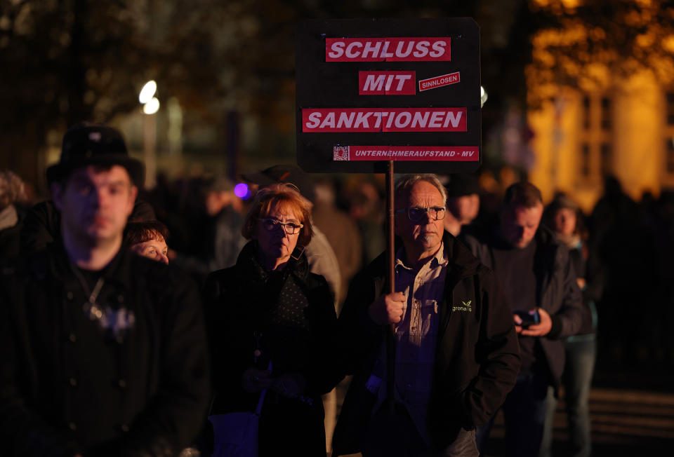 A man holds a sign that reads: "Enough with sanctions" prior to a Monday-night "stroll" ("Spaziergang") of protesters on Oct. 24 in Schwerin, Germany.<span class="copyright">Sean Gallup—Getty Images</span>