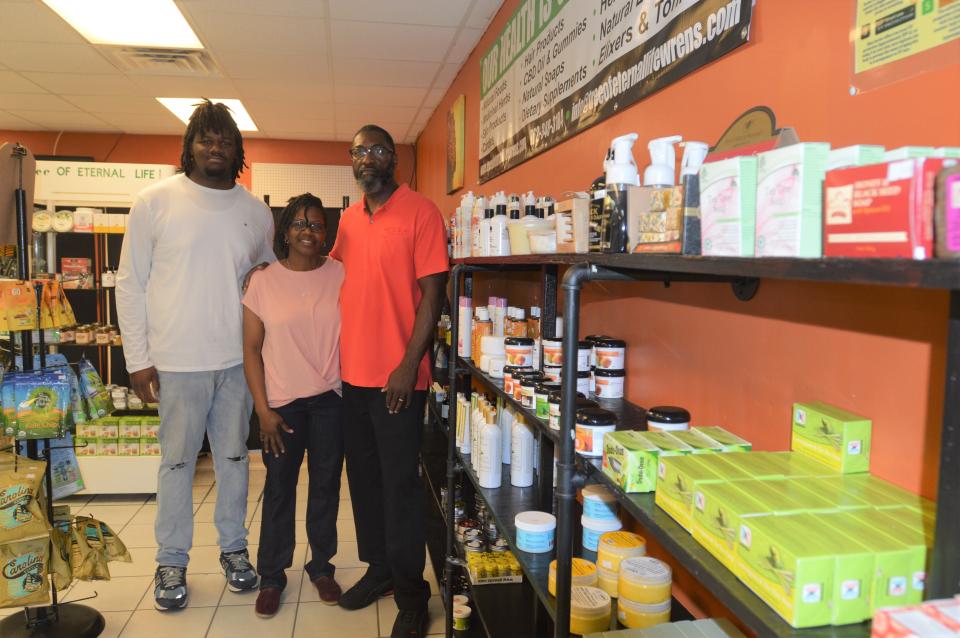 Arthur Wilcher poses with his family in his new store, Tree of Eternal Life.