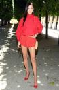 <p>In red romper suit, nude belt bag and red heels while attending the Louis Vuitton men's fashion show in Paris.</p>