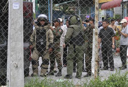 Personnel from the Cambodian Mine Action Center (CMAC) wear bomb disposal suits as they prepare to detonate a bomb that security officials discovered outside of Cambodia's National Assembly in central Phnom Penh, September 13, 2013. REUTERS/Samrang Pring