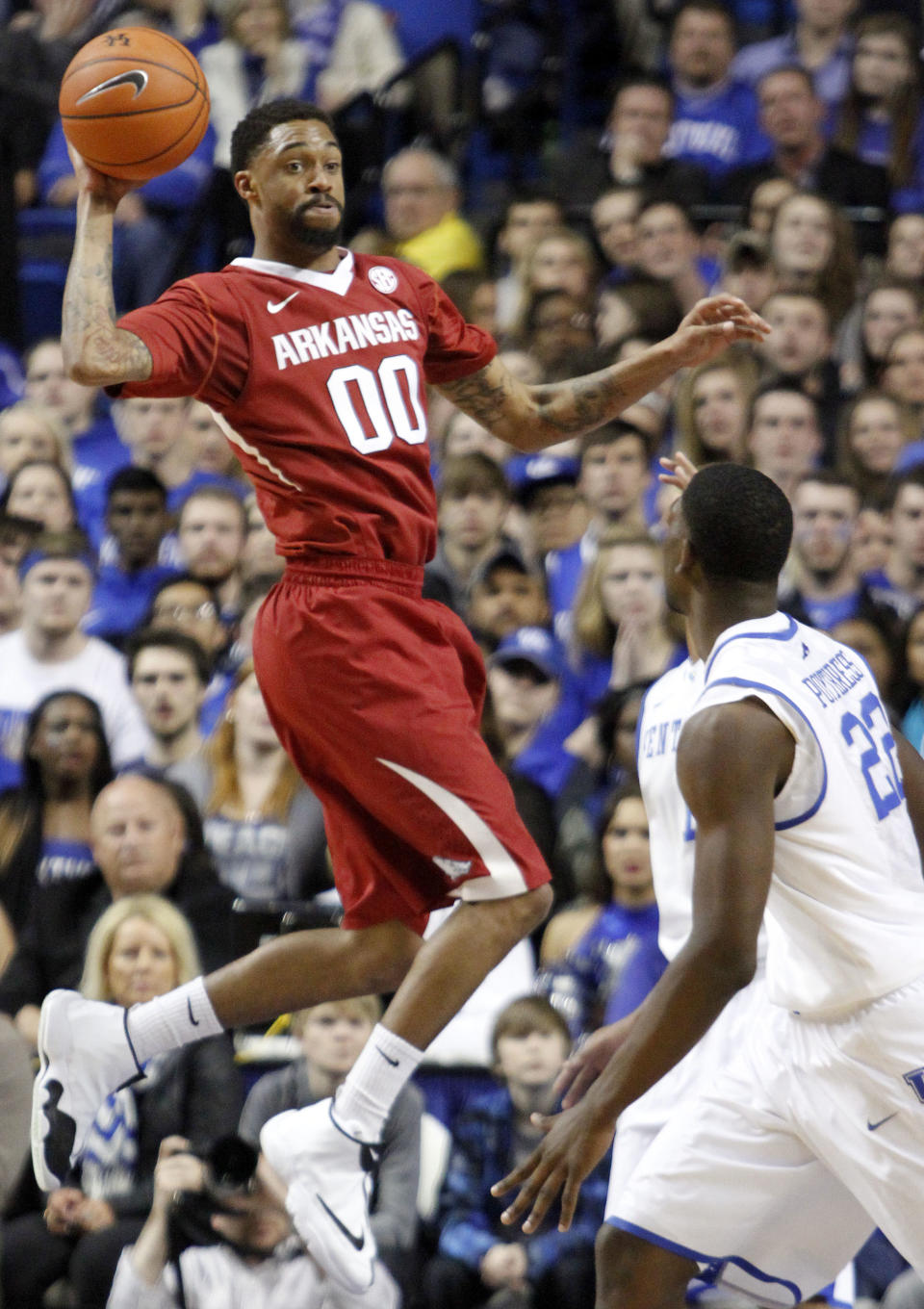 Arkansas' Rashad Madden looks for an open teammate as Kentucky's Alex Poythress (22) watches during the first half of an NCAA college basketball game Thursday, Feb. 27, 2014, in Lexington, Ky. (AP Photo/James Crisp)