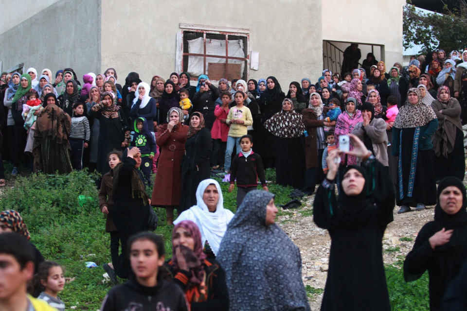 Friends and relatives of Palestinian teenager Yussef Shawamreh mourn outside his house in the West Bank village of Deir al-Asa, south of Hebron, Wednesday, March 19, 2014. The Israeli military said soldiers have shot and killed a Palestinian who was among a group trying to break through the West Bank separation fence. (AP Photo/Nasser Shiyoukhi)