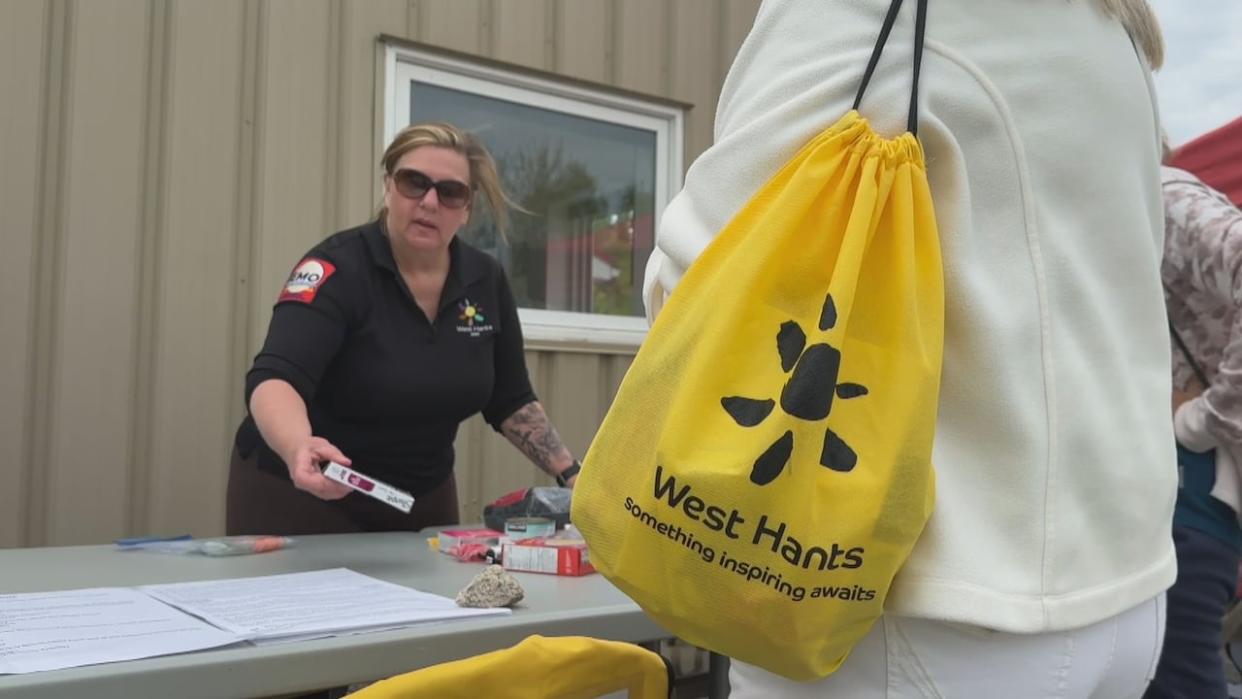 Shelleena Thornton, emergency management co-ordinator for West Hants, explains to residents what's in the emergency preparedness kits being handed out at an education session Sunday.  (Josh Hoffman/CBC - image credit)