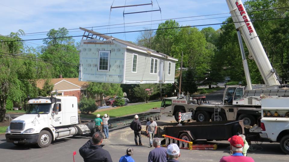 Hoisted by crane onto a flatbed truck, a  modular Habitat for Humanity home built by students at Roxbury High School was moved across town to a permanent location in Landing as the couple selected to own it watches.