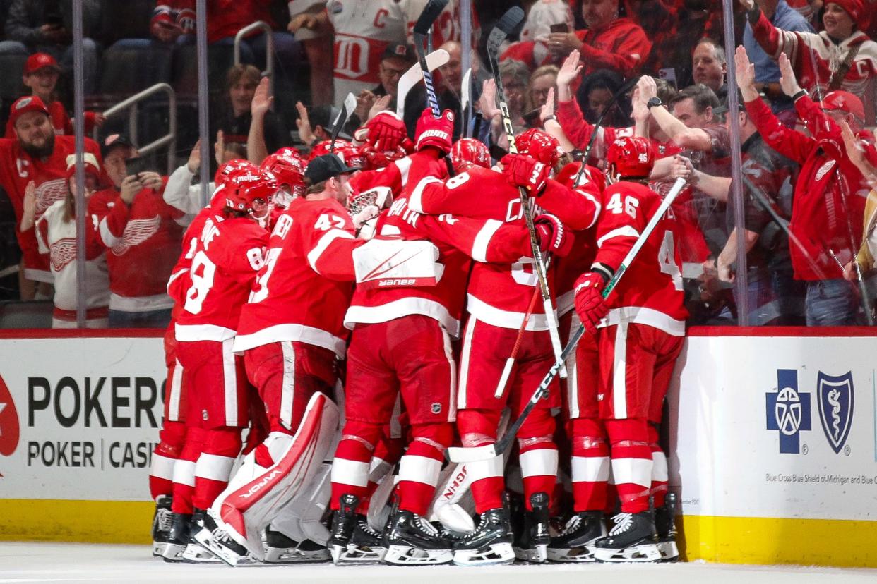 Detroit Red Wings players celebrate a goal scored by left wing Lucas Raymond (23) against Montreal Canadiens during overtime at Little Caesars Arena in Detroit on Monday, April 15, 2024.