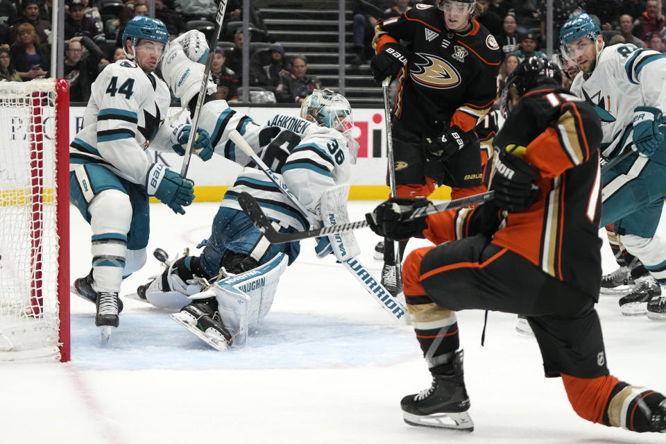 Anaheim Ducks right wing Troy Terry, right, scores a goal past San Jose Sharks goaltender Kaapo Kahkonen, second from left, and defenseman Marc-Edouard Vlasic, left, during the third period of an NHL hockey game Wednesday, Jan. 31, 2024, in Anaheim, Calif. (AP Photo/Mark J. Terrill)