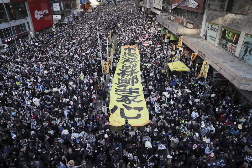 FILE - Pro-democracy protesters march on a street during a protest in Hong Kong, Sunday, Dec. 8, 2019. The recent wave of protests against China's anti-virus restrictions was a ray of hope for some supporters of Hong Kong's own pro-democracy movement after local authorities stifled it using a national security law enacted in 2020, but not everyone agrees. (AP Photo/Kin Cheung, File)