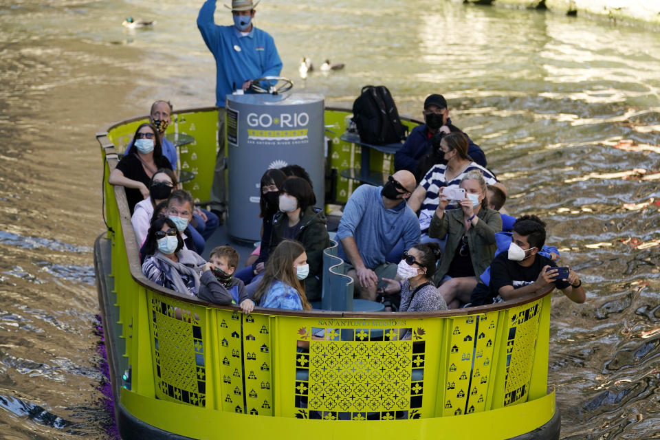 Visitors wear face masks during the coronavirus pandemic as they travel along the River Walk, Wednesday, March 3, 2021, in San Antonio. Gov. Greg Abbott says Texas is lifting a mask mandate and lifting business capacity limits next week. (AP Photo/Eric Gay)