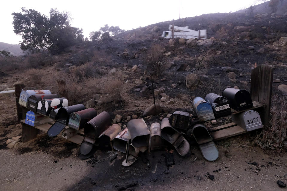 Charred mailboxes lay on the scorched ground following a wildfire Wednesday, Oct. 13, 2021, in Goleta, Calif. (AP Photo/Ringo H.W. Chiu)