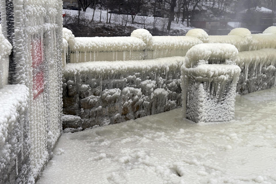 Mist from the Great Falls has created a frozen wonderland around the waterfalls in Paterson, N.J., on Thursday, Jan. 18, 2024. People are braving the subfreezing cold temps and slippery walkways to visit the ice-covered trees, benches and lamposts. (AP Photo/Ted Shaffrey)