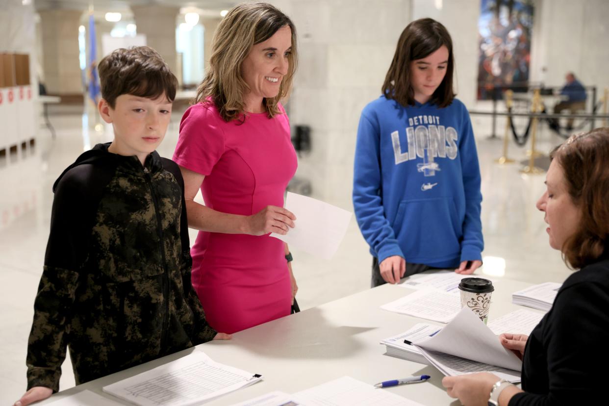 Ellen Pogemiller, with her children, Wesley, left, and Clark, files to run for the House District 88 seat on Thursday, the second day of candidate filings at the state Capitol.