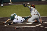 South Florida's Matt Ruiz (6) is tagged out by Texas catcher Silas Ardoin (4) as he tries to score during the fourth inning of an NCAA Super Regional college baseball game, Sunday, June 13, 2021, in Austin, Texas. (AP Photo/Eric Gay)