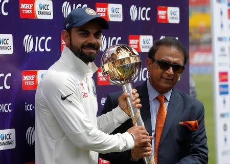 Cricket - India v Australia - Fourth Test cricket match - Himachal Pradesh Cricket Association Stadium, Dharamsala, India - 28/03/17 - India's Virat Kohli receives the ICC Test Mace from former Indian cricket player Sunil Gavaskar (R) after India won the test series against Australia. REUTERS/Adnan Abidi