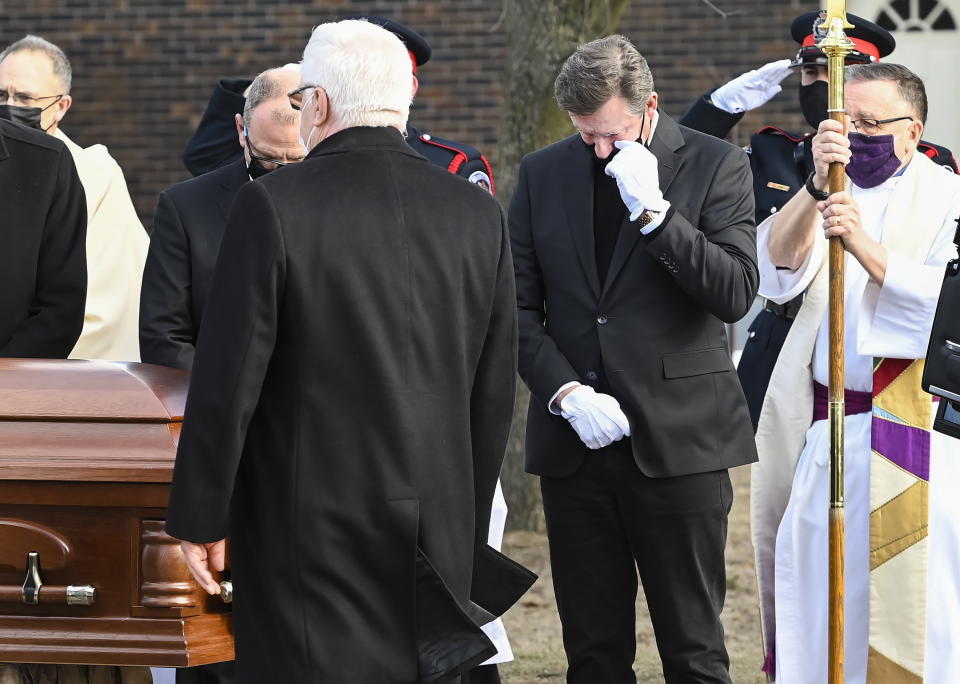 Hockey hall-of-fame legend Wayne Gretzky, right, watches the casket of his father, Walter Gretzky, as it is carried from the church during a funeral service in Brantford, Ontario, Saturday, March 6, 2021. Walter Gretzky, also known as Canada's hockey dad was 82 years old. (Nathan Denette/The Canadian Press via AP)