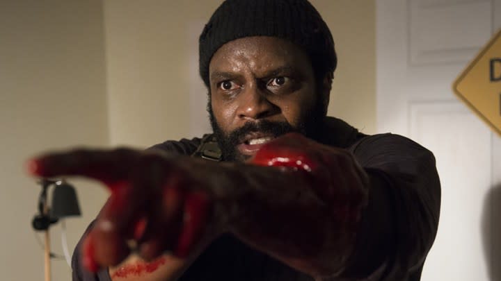 Tyreese holding his blood soaked hands out in front of him, looking distressed in a scene from The Walking Dead.