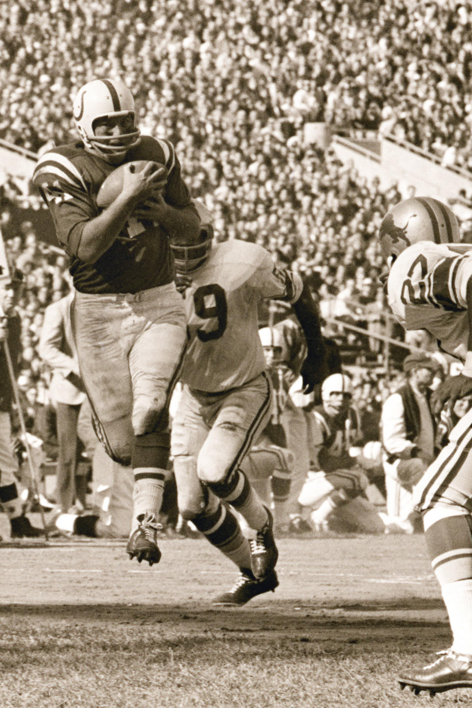 FILE - Baltimore Colts running back Tom Matte grabs a touchdown pass as Detroit Lions defenders Bobby Thompson (27) and John Robinson (49) move in during the second quarter of their football game on Oct. 16, 1966, in Baltimore. Matte, who spent his entire 12-year NFL career as a gritty running back for the Baltimore Colts _ except for a star turn for three games in 1965 as their quarterback _ has died. He was 82. The Baltimore Ravens confirmed Matte's death during coach John Harbaugh's news conference Wednesday, Nov. 3, 2021. No details were provided. (AP Photo/File)