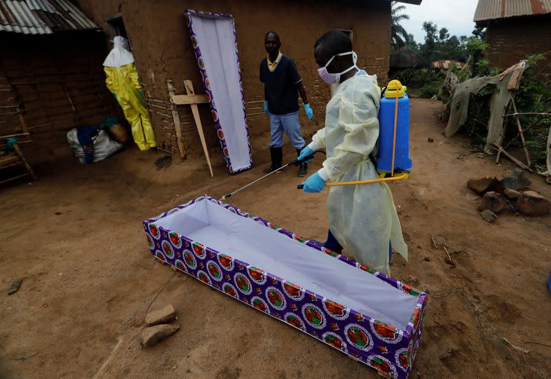 FILE PHOTO: Kavota Mugisha Robert, a healthcare worker who volunteered in the Ebola response, sprays the coffin brought for a woman, 85, who is suspected of dying of Ebola, outside her house in the Eastern Congolese town of Beni