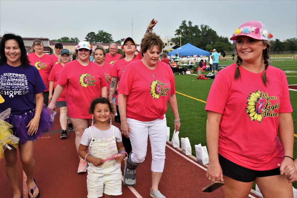 Participants in the Relay For Life event walk the Erhard Field track on Saturday.